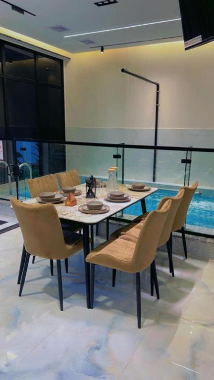 a dining room with a table and chairs at فلة جديدة راقية بمسبح داخلي Luxury villa with indoor pool in Taif
