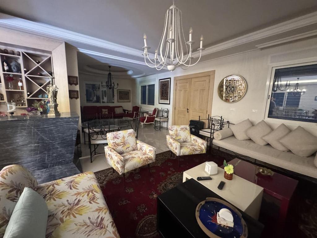 a living room with a couch and a table at Blue House- Peaceful Mountain Escape in Mazraat et Teffâh