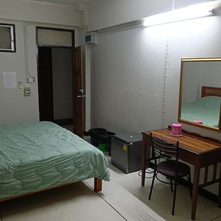 a bedroom with a bed and a desk and a mirror at Viriyapon in Bangkok