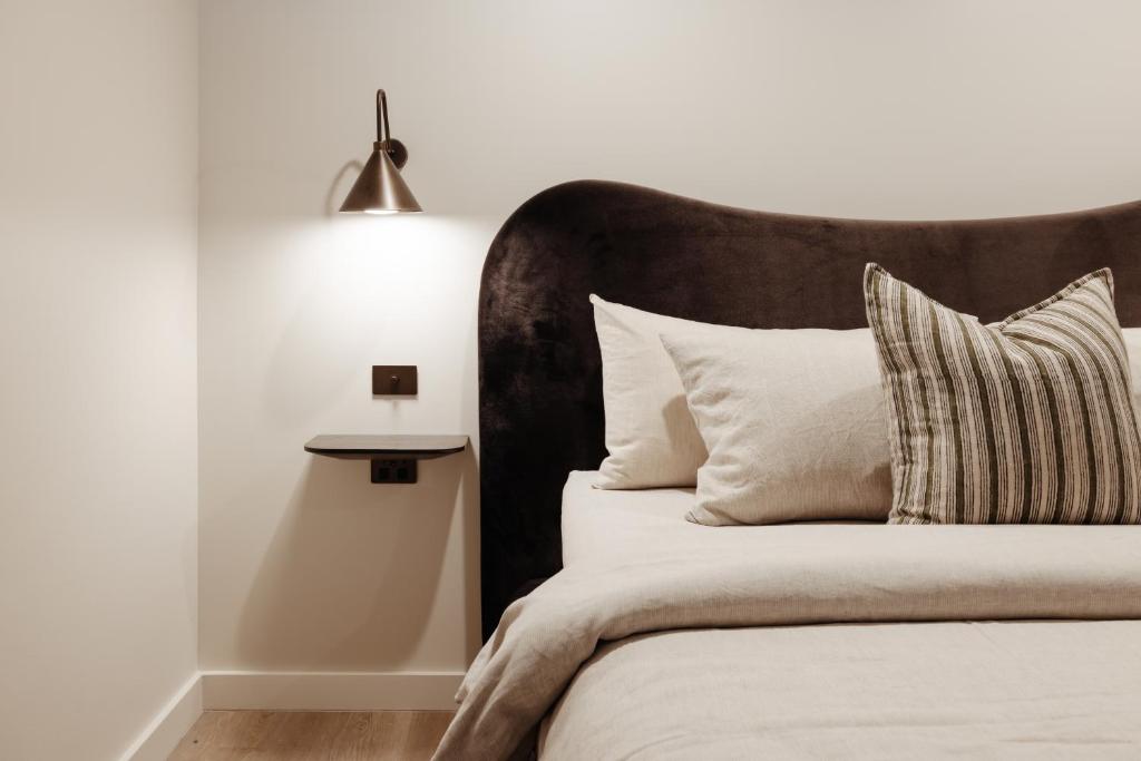 a bedroom with a bed with a black headboard at Sola Studios in Margaret River Town