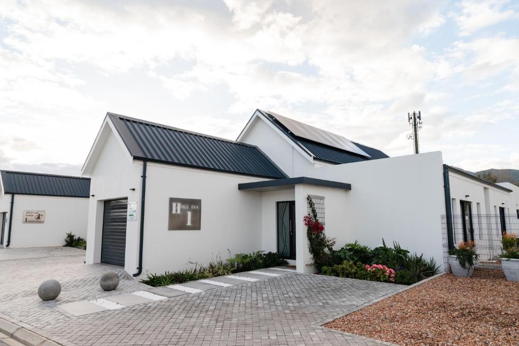 a white house with solar panels on it at Hole Inn 1 in Robertson