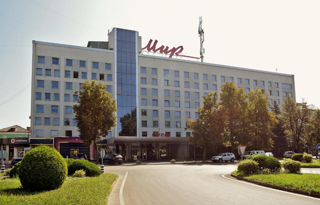 a large building with a sign on the top of it at Hotel Mir in Rivne