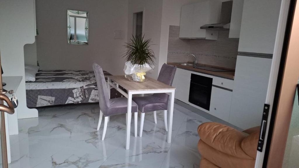 a kitchen with a table and chairs and a bedroom at Skizzo residence in Santa Maria degli Angeli