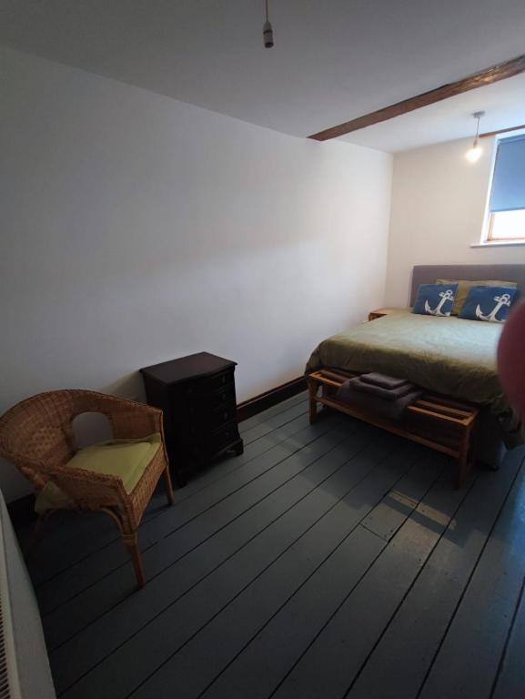 a bedroom with a bed and a chair in a room at The Courtyard Hideout in Hereford