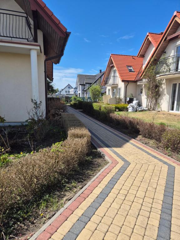 a cobblestone street in a residential neighborhood with houses at Polanki10 Łebski Dworek u Anity in Nowęcin