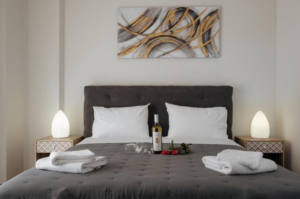 a bedroom with a bed with a bottle of wine and towels at Soro Rooms in Kanali