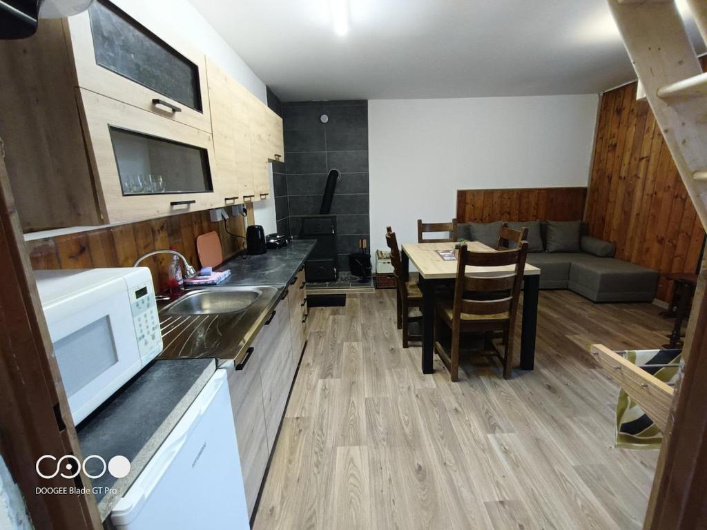 a kitchen and living room with a table and a couch at Chatička For Funny in Horní Slavkov
