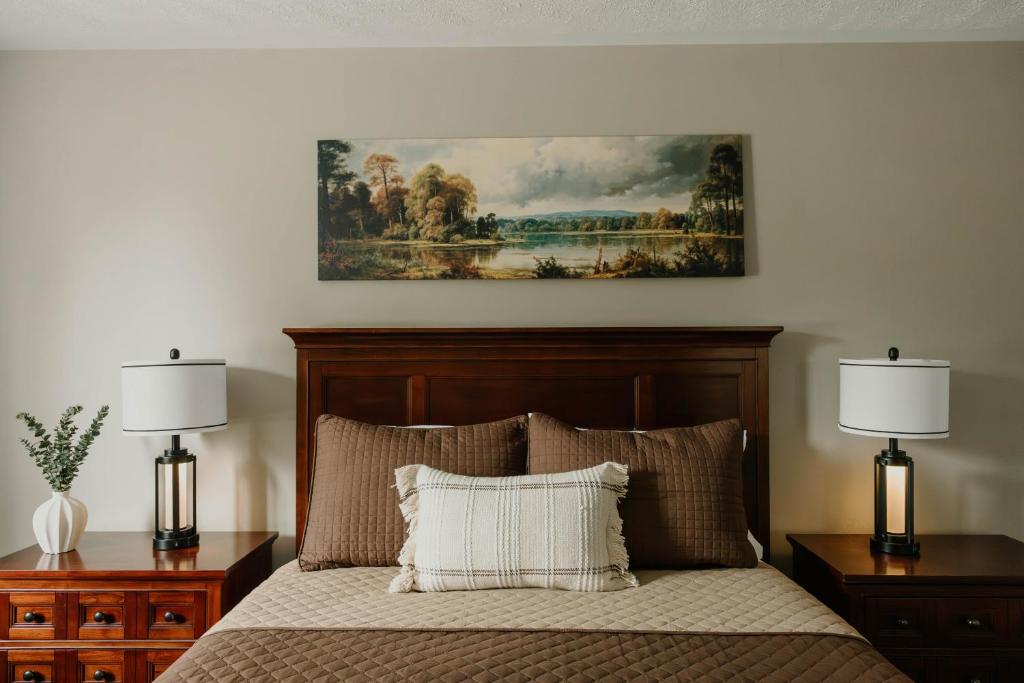 a bedroom with a bed with two night stands and two lamps at Manitoulin Inn in Mindemoya