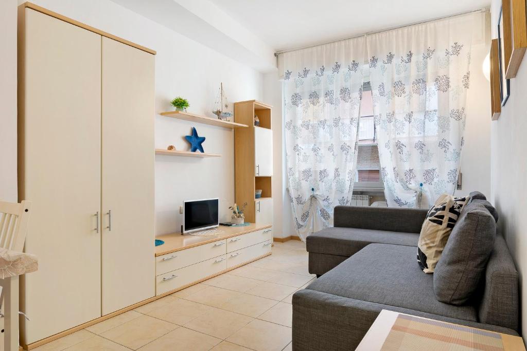 a living room with a couch and a tv at Fontanine House in Rapallo
