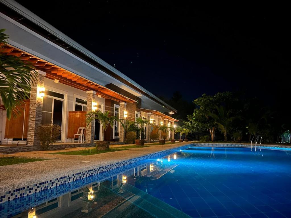 a swimming pool in front of a house at night at The Retreat in Panglao Island
