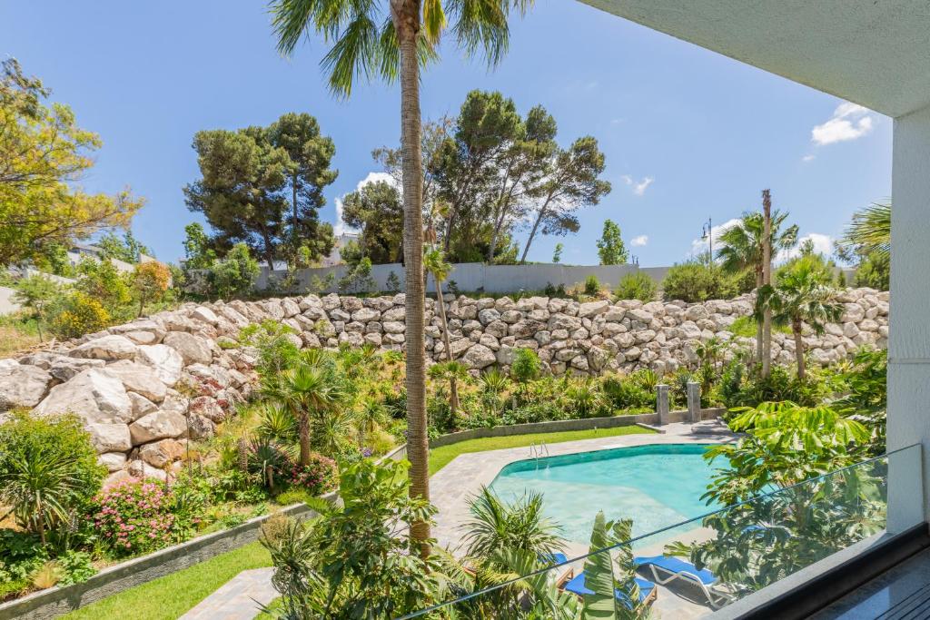 a swimming pool in a yard with a stone wall at Seaside Pool View 3BR Apt with 2 Balconies in Tangier