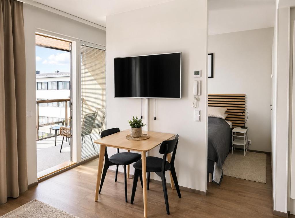 a bedroom with a bed and a table with chairs at Teljänkatu 4 in Pori