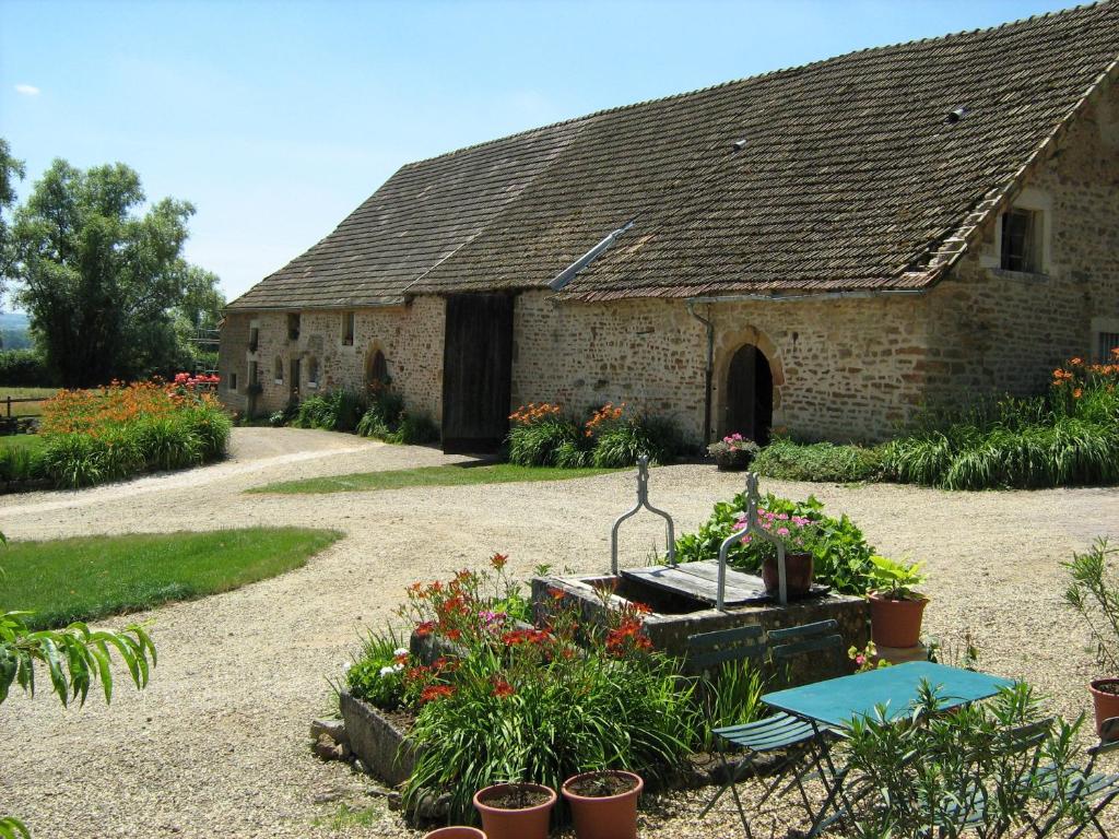 an old stone building with flowers in front of it at La Ferme du Mont in Foissy