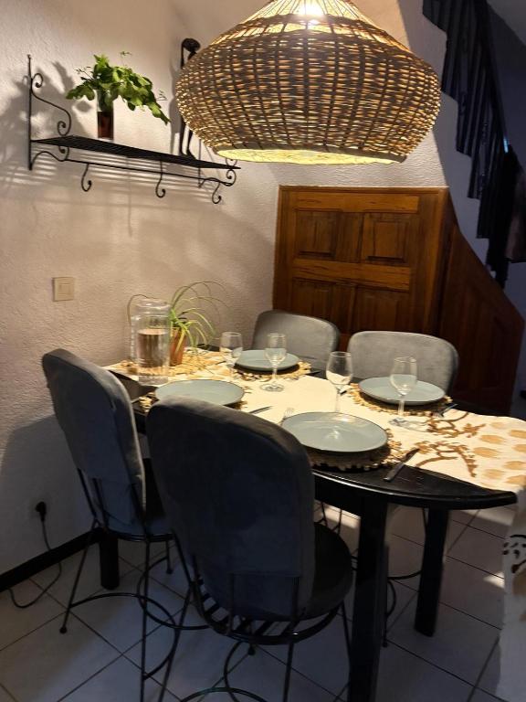 a dining room table with chairs and a large chandelier at Coin du paradis in Saly Portudal