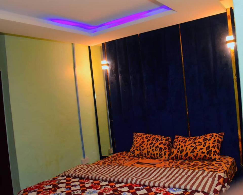 a bedroom with a bed with cheetah pillows at Clint Cottage Hotel in Odo