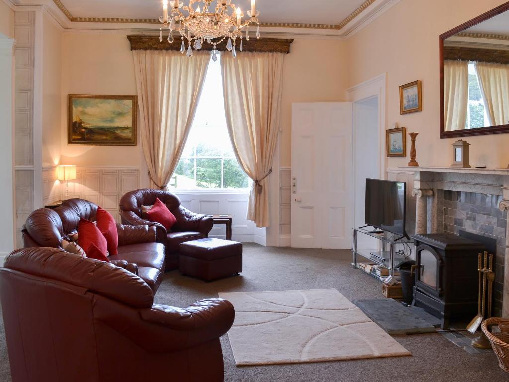 a living room with two leather chairs and a television at Foulston Apt- Cv12 in Liskeard