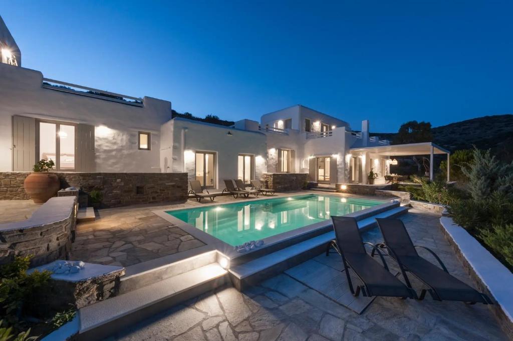 a villa with a swimming pool at night at Luxury Complex Ninemia Villas in Faros