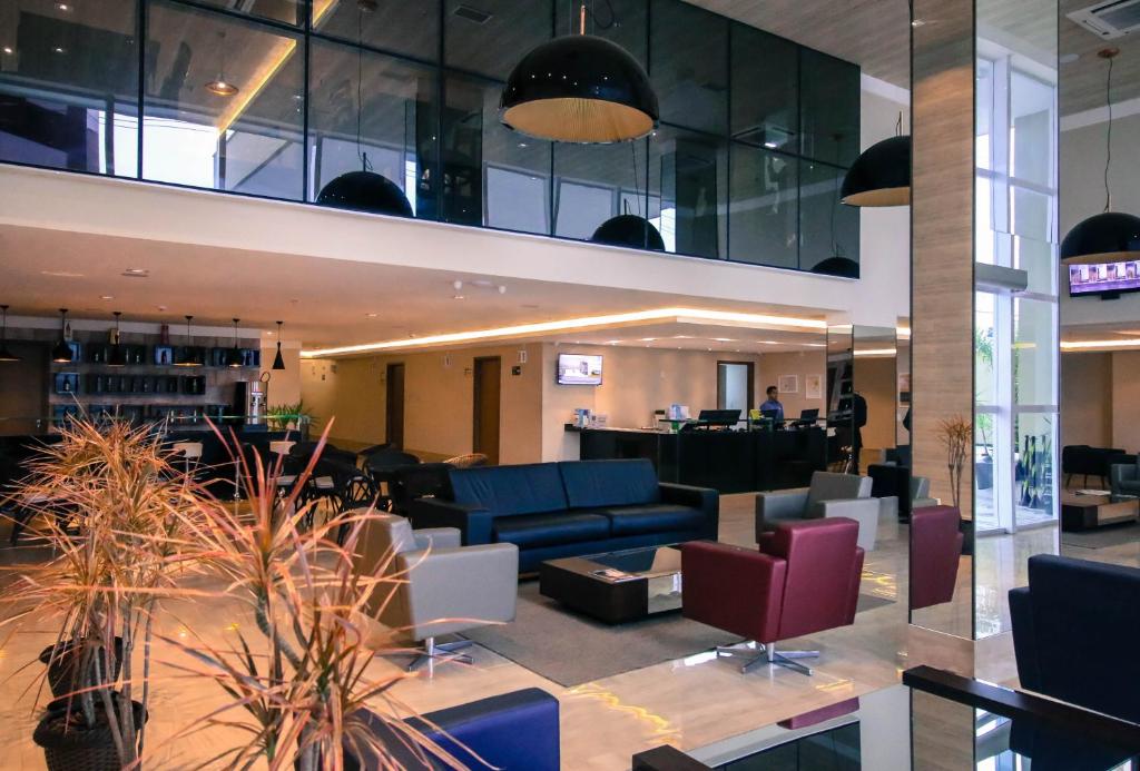 a lobby with couches and chairs in a building at Ibiza Plaza Hotel in Anápolis