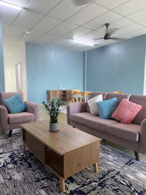 a living room with two couches and a coffee table at Tido Cottage in Macang