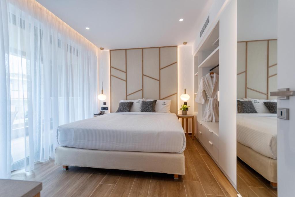 a bedroom with two beds and a large window at Lemar Luxury Apartments in Hersonissos