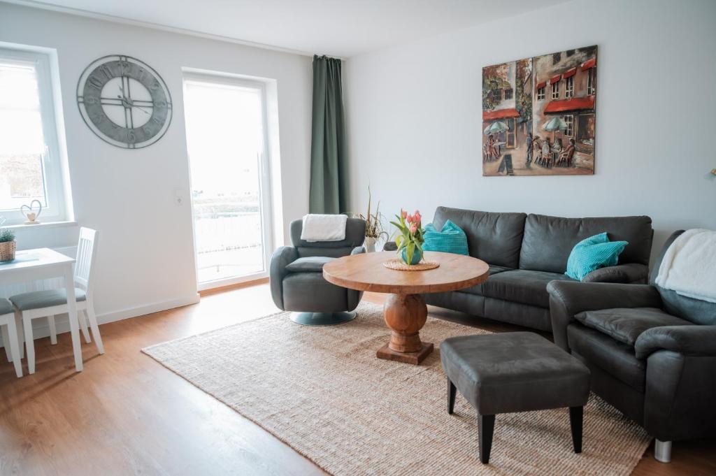 a living room with a couch and a table at Ferienwohnungen Blischke in Carolinensiel