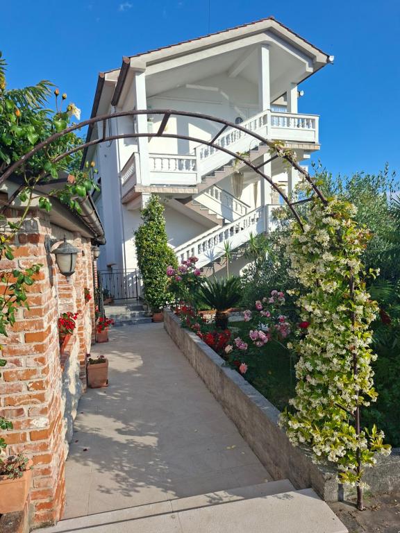 a white building with a balcony and flowers at Apartmani Dijana in Rab