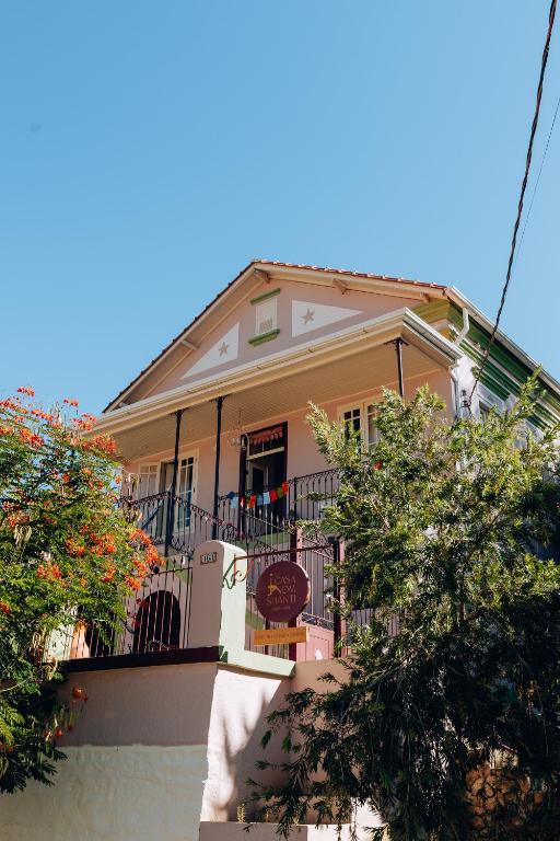 a yellow house with a balcony and trees at Casa Om Shanti in Passa Quatro