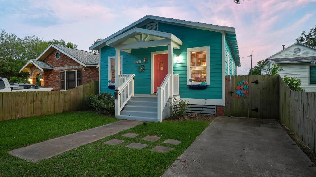 a blue house with a fence in a yard at Sandy Turtle-Gone to the Beach Be Back Never in Galveston