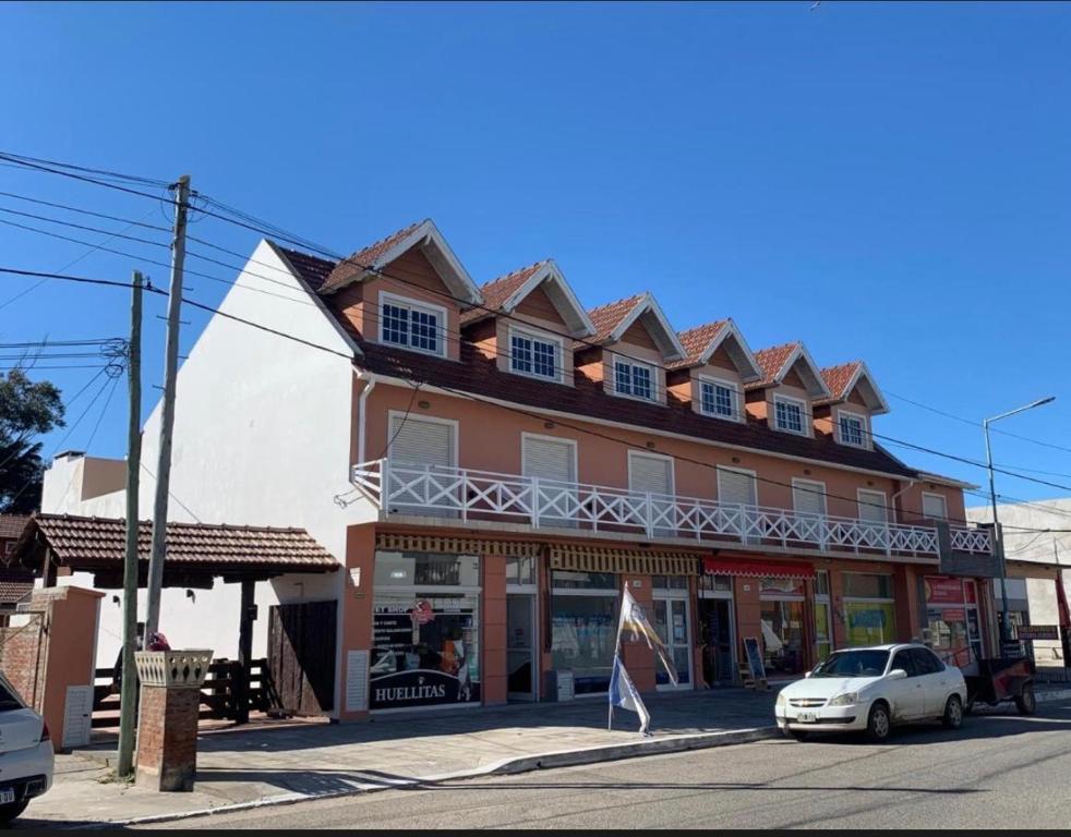a building with a car parked in front of it at Arcángel san Miguel in Las Toninas