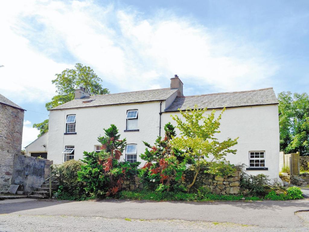 a white house with a stone wall at Foldgate in Waberthwaite
