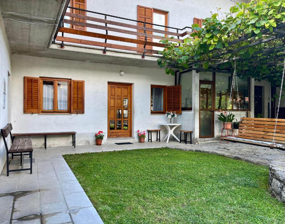 a house with a patio and a grass yard at Apartma Danijela in Kanal