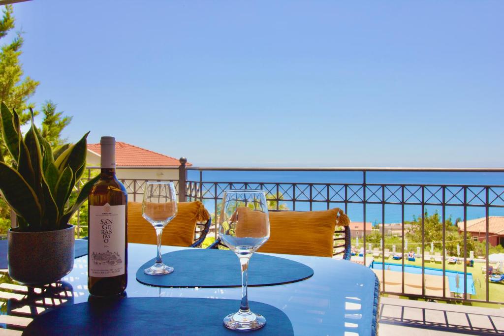 a table with two wine glasses and a bottle of wine at PNOẼ Luxury Apartments in Lourdata