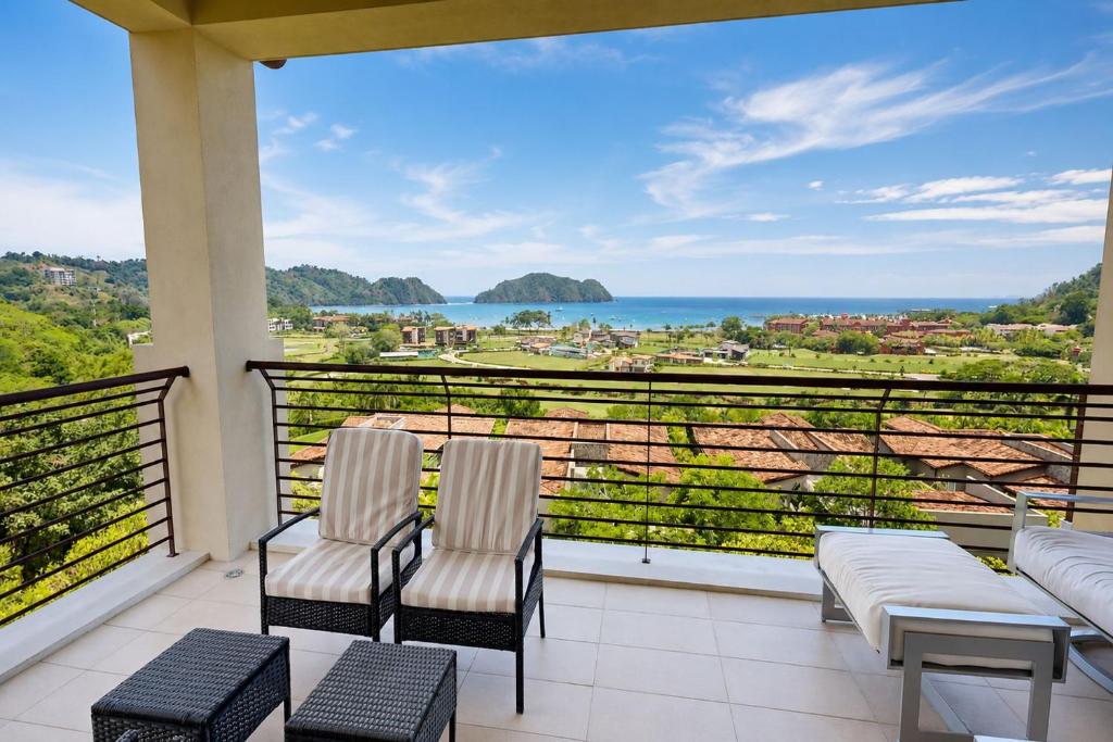 a balcony with two chairs and a view of the ocean at Miramar 5B 2 bdr Ocean View in Los Suenos in Herradura