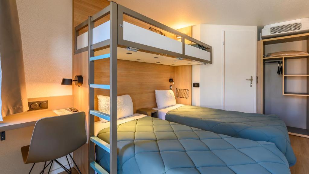 a bedroom with two bunk beds and a desk at Premiere Classe Versailles - Saint Cyr L'ecole in Saint-Cyr-lʼÉcole