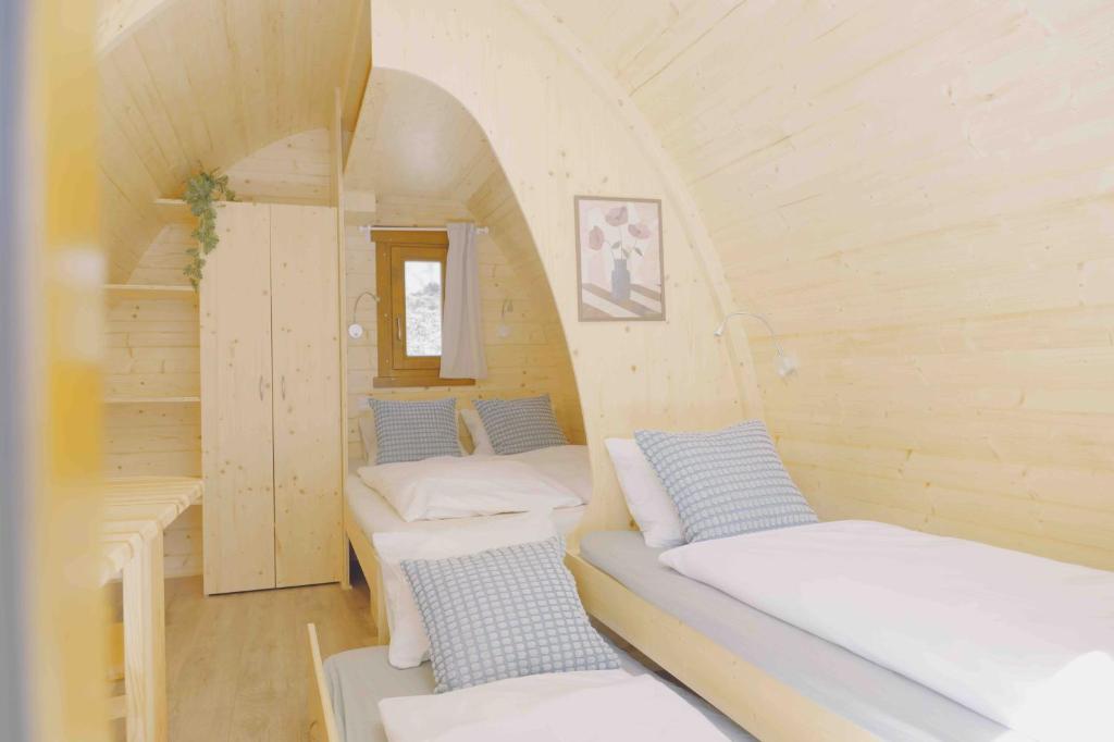a room with three beds in a small room at Traumhafter POD-M mit Seesicht - mit Terrasse aber ohne privates WC in Alpnach