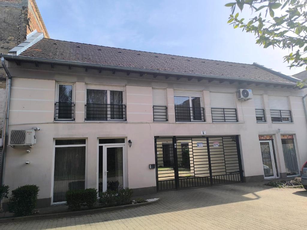 a white house with black windows and doors at FAVORIT CENTRUM Apartman in Kaposvár