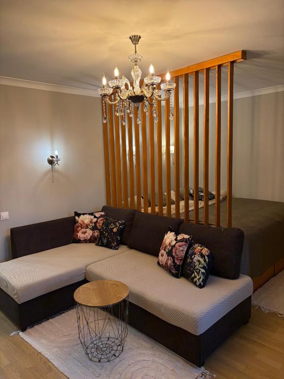a living room with a couch and a chandelier at the HAPPY PLACE in Mykolaiv