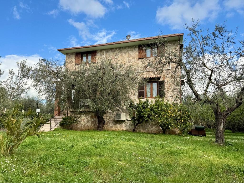 an old stone house on a grassy field at La Piccola Provenza in Fiano Romano