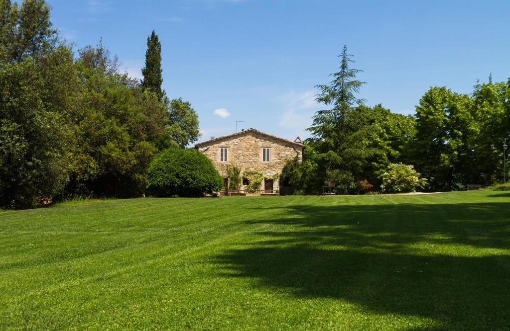 um grande campo relvado com uma casa ao fundo em Agriturismo La Fonte em Ponte Pattoli