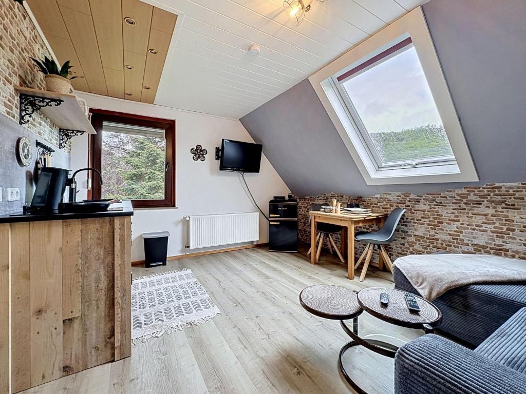 a living room with a couch and a table at Apartment Eifelhome One nahe Nürburgring by Interhome in Fuchshofen