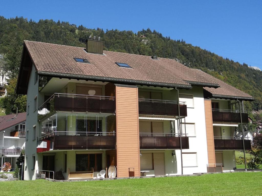 a large apartment building with a mountain in the background at Apartment Blumenweg 8 by Interhome in Engelberg