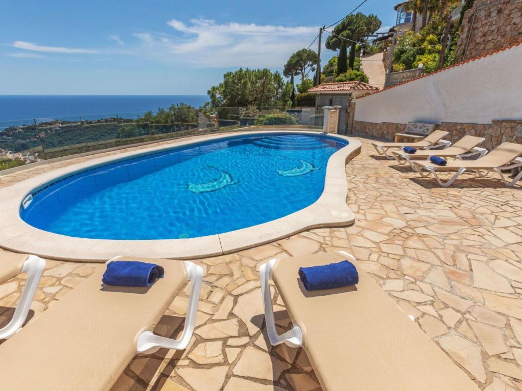 a swimming pool with two lounge chairs next to it at Holiday Home Floramar by Interhome in Lloret de Mar