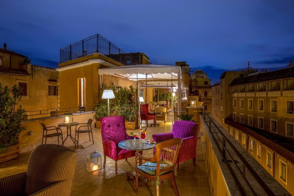 a patio with tables and chairs on a balcony at Hotel Monte Cenci in Rome