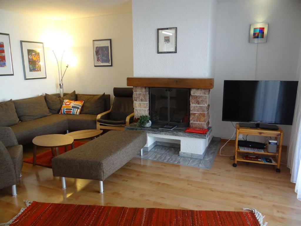 a living room with a couch and a fireplace at Apartment Dorfstrasse 53a by Interhome in Engelberg
