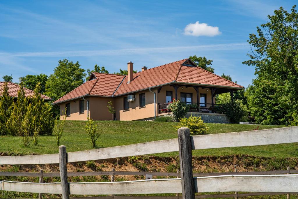 a house on a hill with a fence at Panoráma Vendégház Bükkösd in Bükkösd
