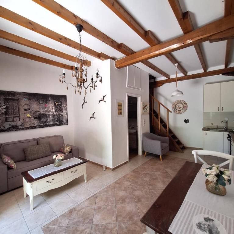 a living room with a couch and a table at Casa di Sofiana by wood and stone in Áyios Pétros