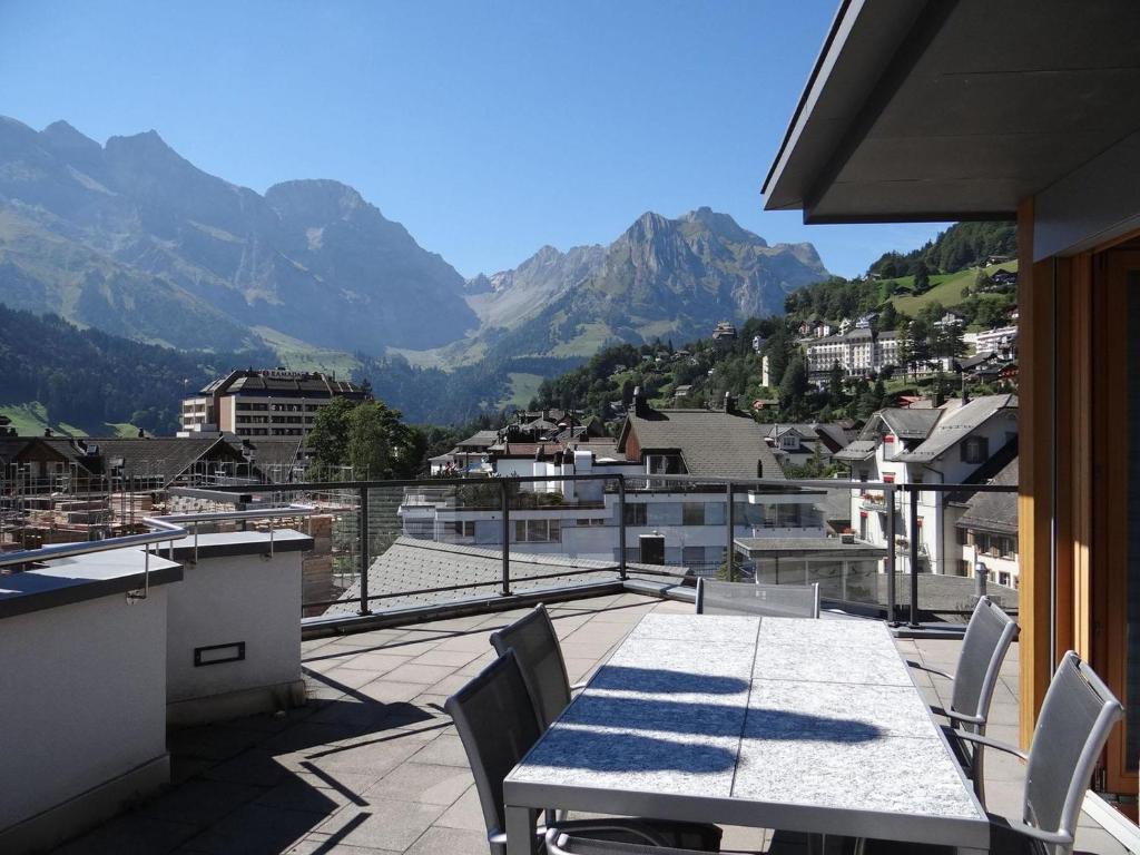 a table and chairs on a balcony with mountains at Apartment Dorfstrasse 7-42 by Interhome in Engelberg