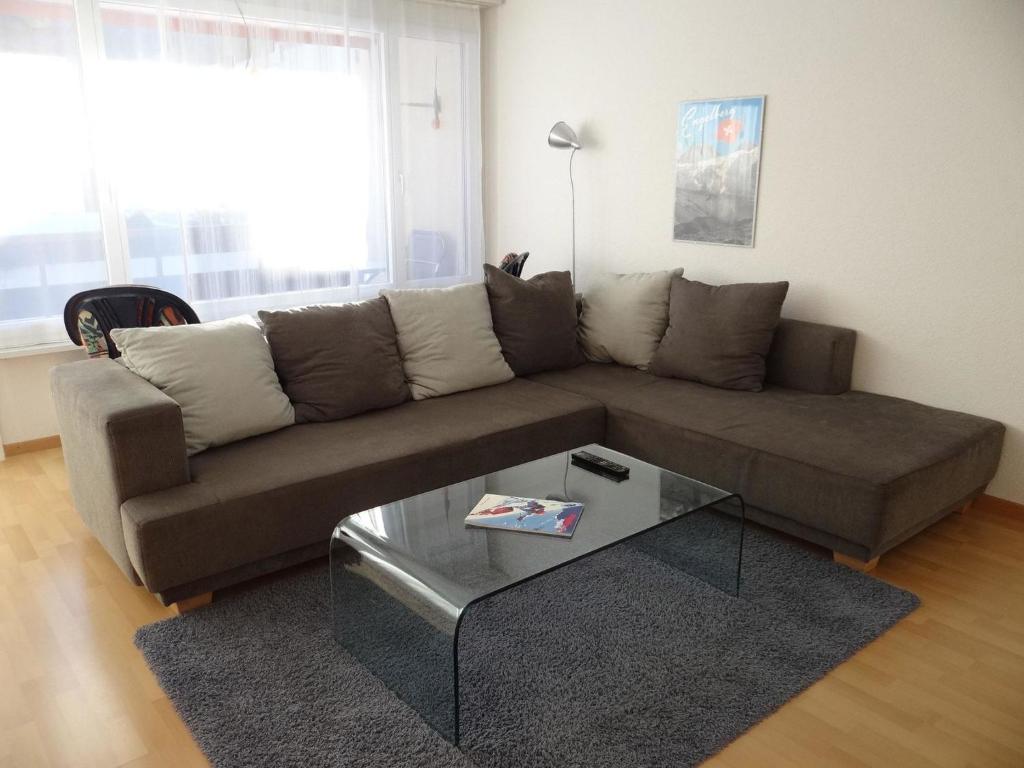 a living room with a couch and a coffee table at Apartment Neuschwändi 66 by Interhome in Engelberg