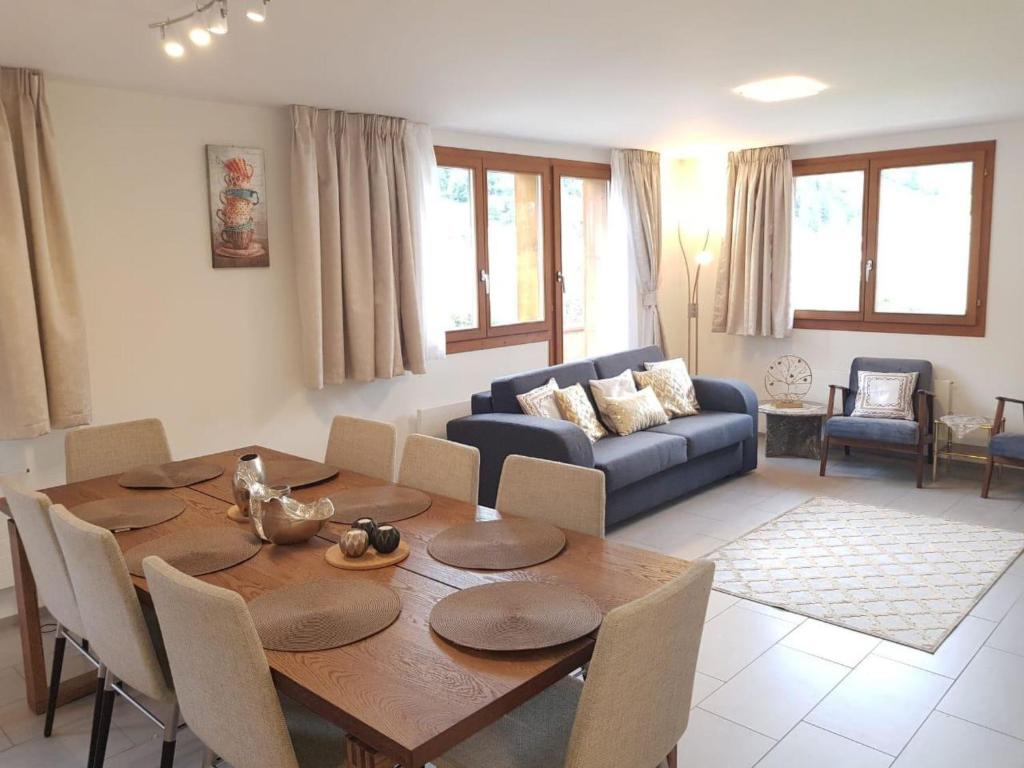 a living room with a wooden table and a couch at Apartment Alpenstrasse 1 by Interhome in Engelberg