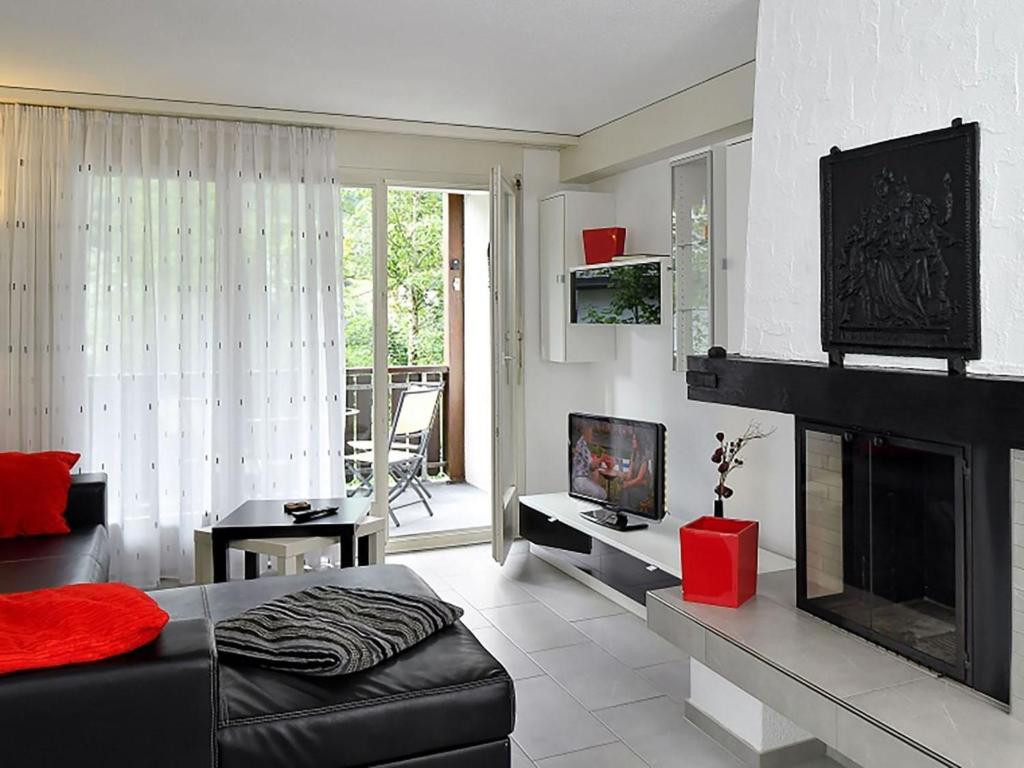 a living room with a couch and a fireplace at Apartment Dorfstrasse 53c by Interhome in Engelberg